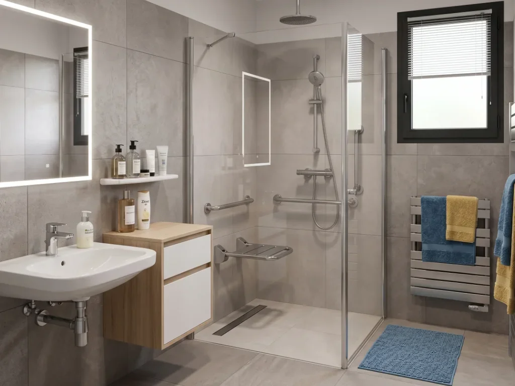 Salle de bain PMR à Mauguio avec douche à l'italienne et barres de maintien dorées.