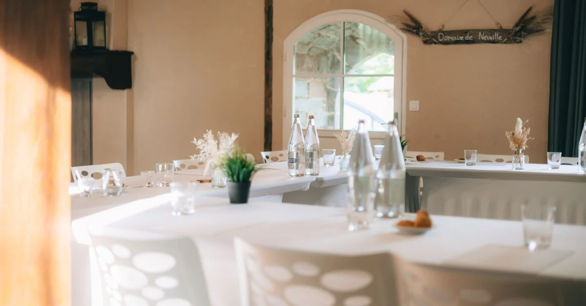 Salle de banquet élégante avec tables vides et décoration, prête pour un événement.
